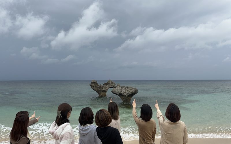 沖縄・古宇利島のハートロックを指差す参加者たち